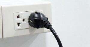 Photo of an electrical socket with a Schuko plug plugged into it.